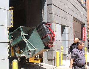 Photo by Bill Egbert Once the carts are rolled up to the compactor, it tips the contents back into the dumpster, where a hydraulic press compacts the trash to the rear of the container to make room for more.