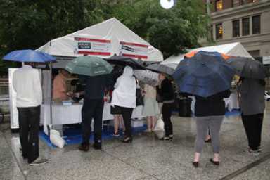 Umbrelled lines of the hungry.
