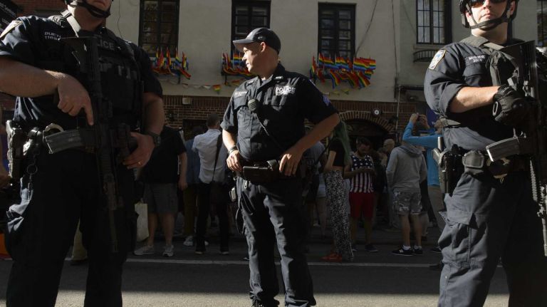 Heavily armed members of the NYPD stand in front of The Stonewall Inn in Manhattan as people gather at a vigil for the victims of the mass shooting attack in Orlando, Fla., on Sunday, June 12, 2016. A gunman armed with an assault rifle and handgun killed 49 people and wounded 53 at Pulse, a gay nightclub in Orlando, in what officials termed the worst mass shooting in U.S. history.