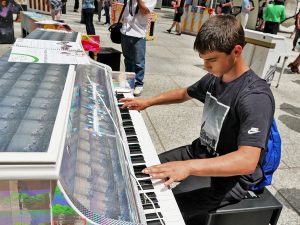 Photo by Milo Hess Albert Cordone, a 15-year-old student at Curtis High School in Staten Island crossed the water to Downtown to try out the Sing for Hope pianos on display.