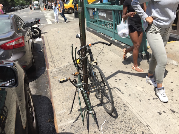 One of these things is not like the other: a derelict bike at W. 15 St. & Eighth Ave., on the scene for over three years, doesn’t meet current city standards for removal. To its right, a fully equipped counterpart. Photo by Sean Egan.