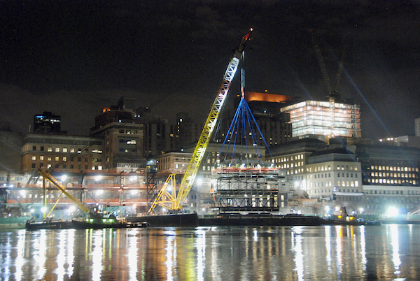 A module for the Rockefeller University expansion being lifted over the FDR Drive, which can be seen with green fencing immediately at river-level to the left of the crane. | FRANK FARANCE 