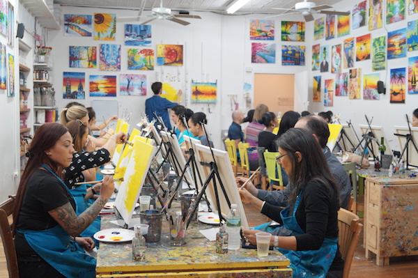 At the Painting Lounge, people keep their eyes on their paintbrushes as they listen to instructor Charles Sommer. Photo by Nicole Javorsky.