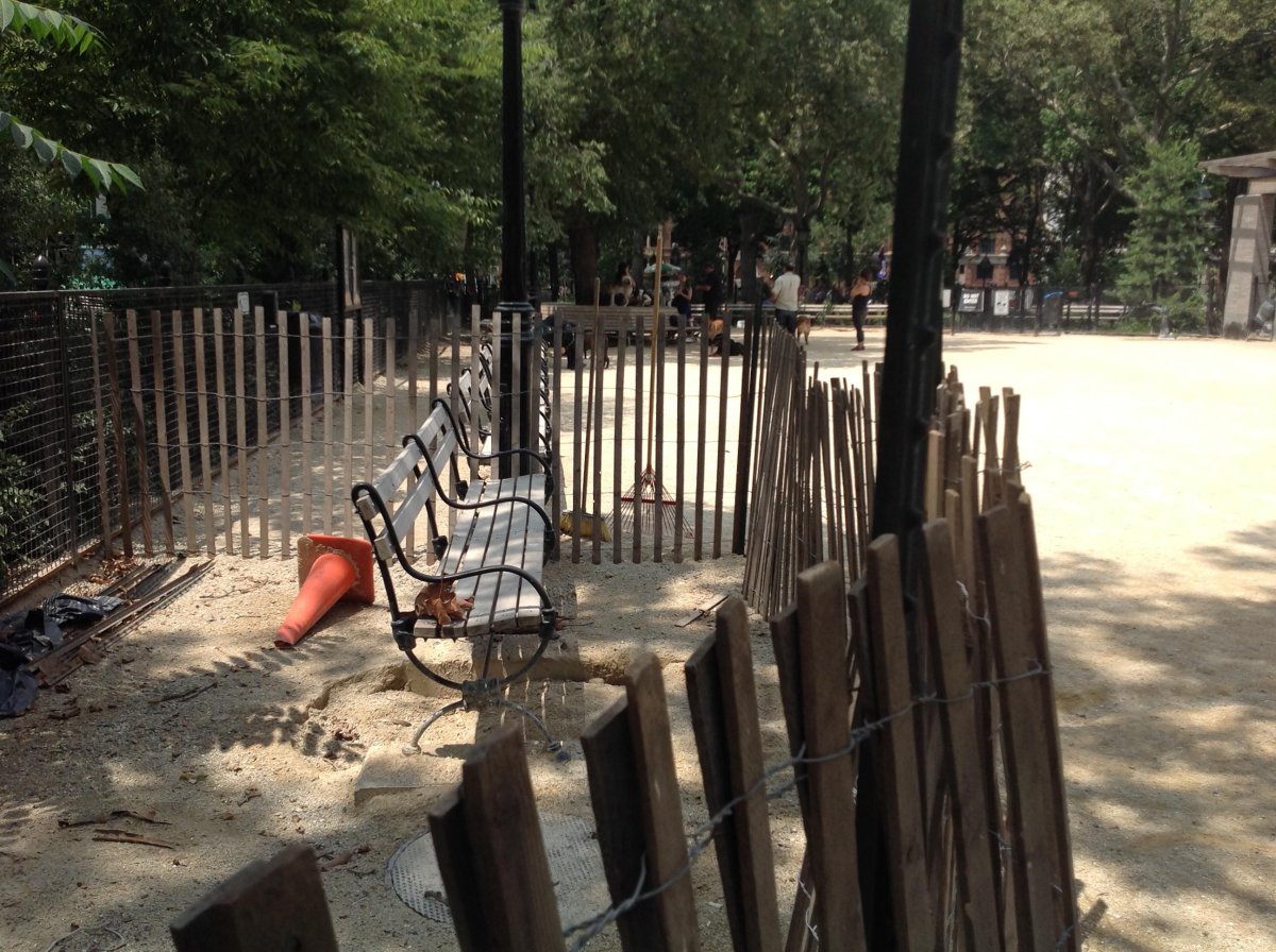 A wooden fence cordons off an area of the Washington Square Park dog run that “collapsed” three months ago, according to dog run members.  Photos by Chriss Williams