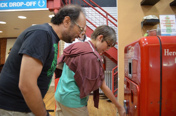 David Cohen and his son Zac using the 1950s Coca-Cola vending machine in Tekserve. Photo by Alex Ellefson.