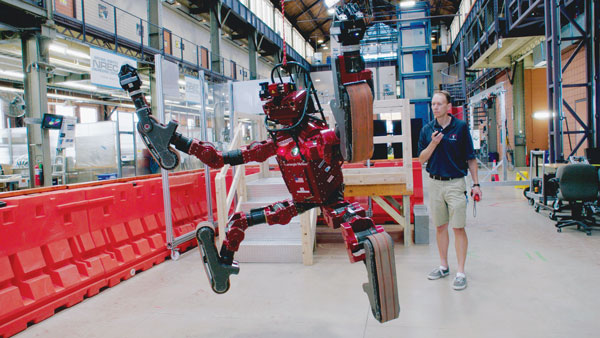 A scientist shows off a highly advanced, problem-solving robot. Courtesy Magnolia Pictures.