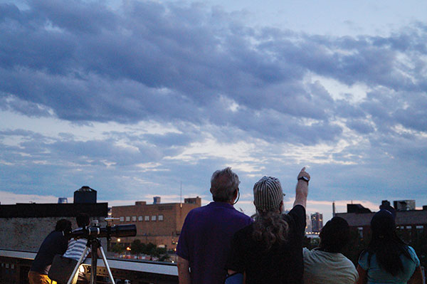 Carey Horwitz, left, and another Amateur Astronomers Association member search the sky, deciding where to point the telescope. Photo by Nicole Javorsky.