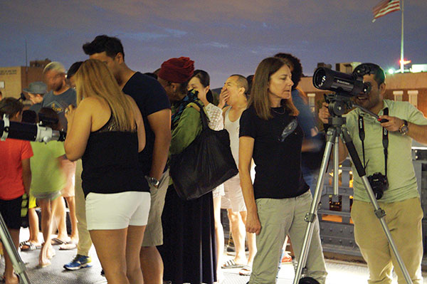 Faissal Halim, right, works with another Amateur Astronomers Association member to adjust one of the telescopes. Photo by Nicole Javorsky.