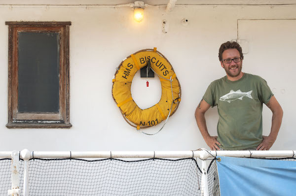 Adam Payne with one of his “Full Steam Ahead” works, installed at the Lilac through September. Photo by Sam Monaco.