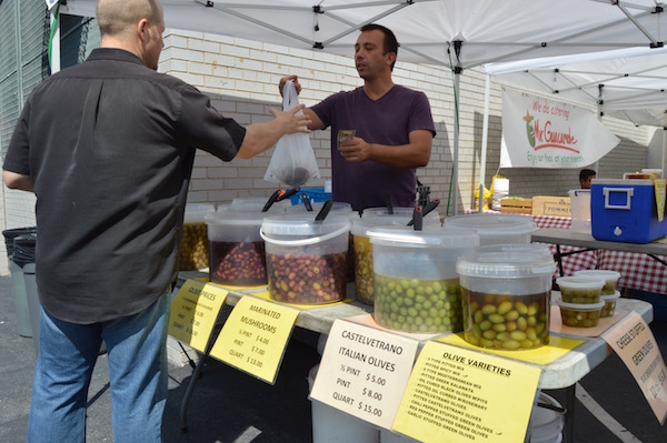 UWS Sunday Market Aims at Reflecting City’s Vibrancy 2 Simon Karaben, of Pickles, Olives, Etc., completes a sale. | JACKSON CHEN
