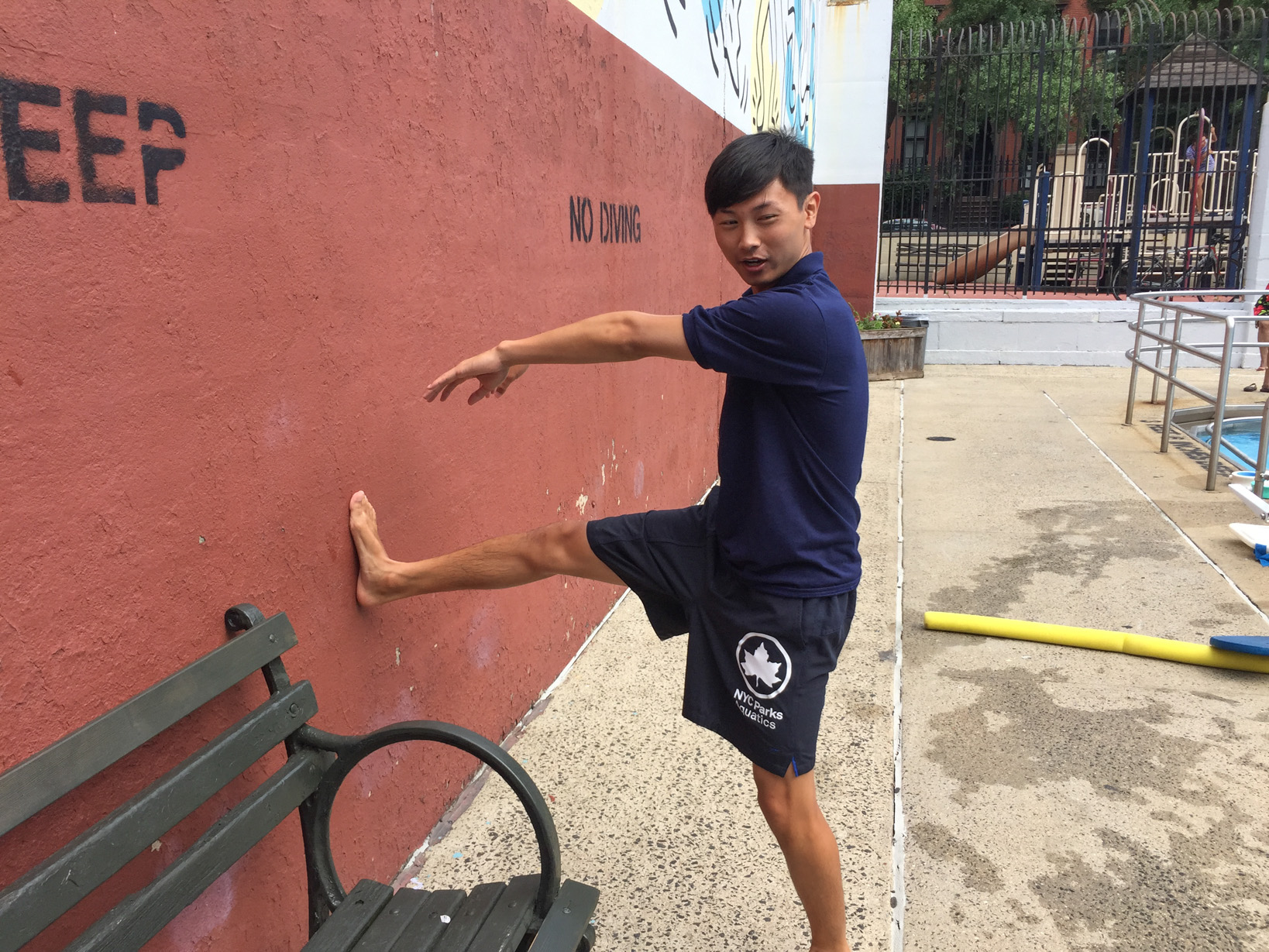Huang demonstrates proper technique for an exercise against the poolside.