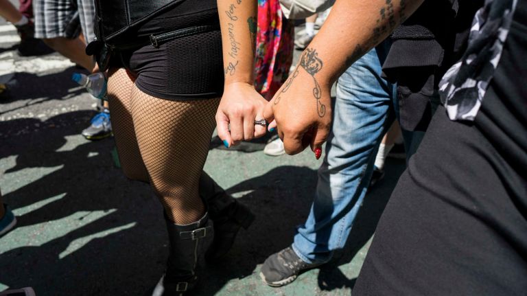 A couple holds hands as they march in the GoTopless Pride Parade on Sunday, Aug. 28, 2016, in Manhattan.