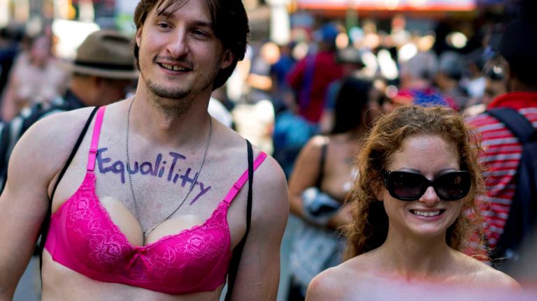 A man and woman march in the GoTopless Pride Parade on Sunday, Aug. 28, 2016, in Manhattan. 