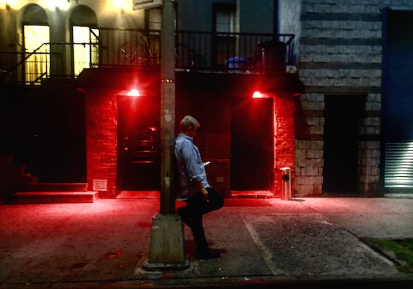 Reading in the red: Outside W. 22nd St.’s Barracuda bar, Aug. 30.