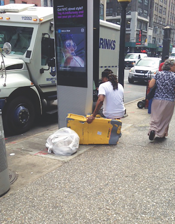 A LinkNYC user parked at a kiosk on Eighth Avenue. | DUSICA SUE MALESEVIC 