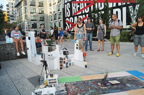 High Line goers pause to look at the structure displaying artwork made by previous visitors to the elevated park. Photo by Nicole Javorsky.