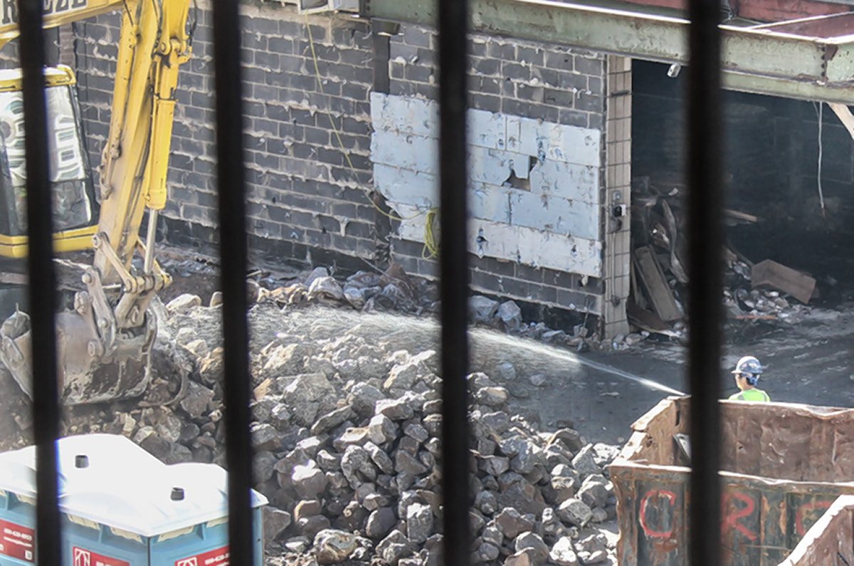 Dust in the wind: Coles gym demo hits Mercer St. 2 Photographed from the overlooking window of Marianne and Paul Edwards, a construction worker at the Coles site can finally be seen turning on one hose around 3:30 p.m. Tuesday to wet down the dusty construction debris. The couple had been complaining all day long. Photo by Tequila Minsky