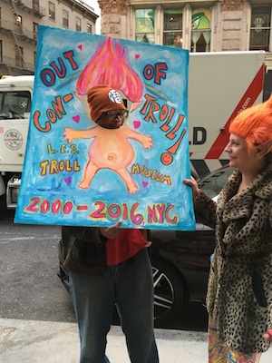 A passerby tries having Troll hair, as Rev. Jen makes her way to a screening of the film whose title creatures were a museum before they were a movie. Photo by John Foster.