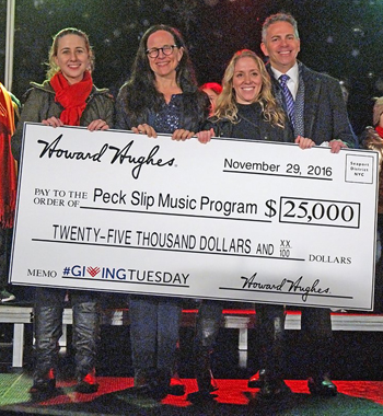 Photo by Milo Hess Seaport developer Howard Hughes Corp. got into the spirit of “Giving Tuesday,” with CEO David Weinreb, at the far right, handing over a $25,000 donation to Peck Slip School principal Maggie Siena, second from left, to fund music programs.