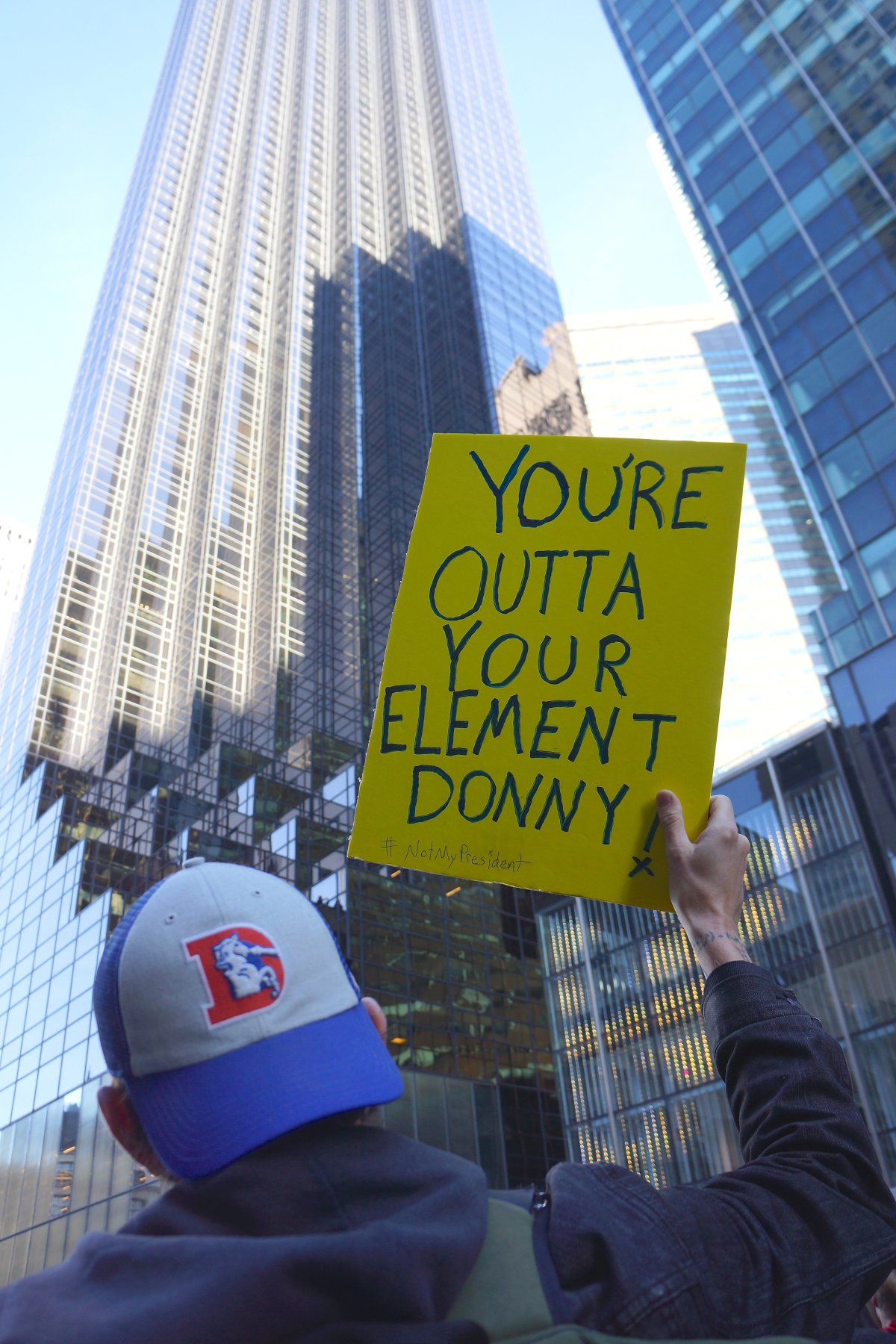 A demonstrator outside Trump Tower at Saturday’s huge “Not My President” march. His sign might be saying two things: that Trump is not up to the job of being president and that he’s “out of his element” in his own hometown. Photo by Sarah Ferguson