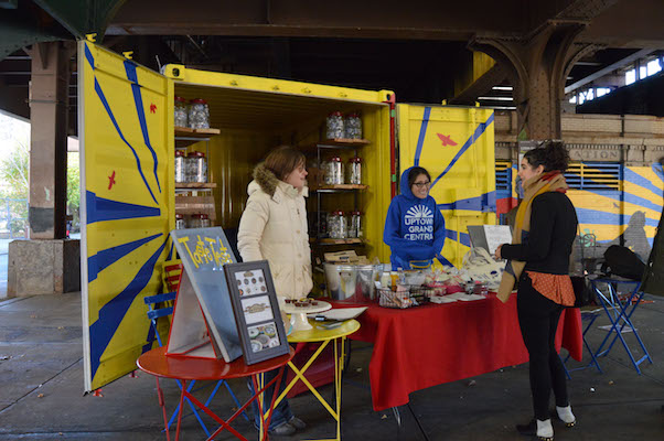 Jessica Taige of Jessie’s Nutty Cups and Carey King of the New East Harlem Merchants Association chat with a passerby at the pop-up shop below the Metro North station at 125th Street and Park Avenue on Small Business Saturday. | JACKSON CHEN 