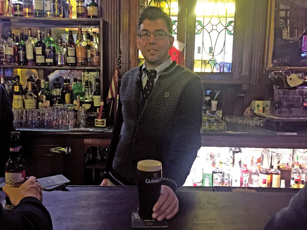 Peter McManus Café Still Serving Pints Despite Closure Scare 1 Third-generation owner Justin McManus serves up a well-poured Guinness over the original bar his grandfather installed at the watering hole in 1933. Photo by Dennis Lynch.