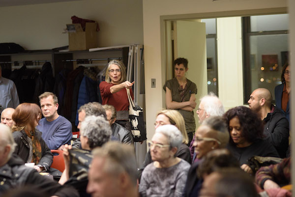 Tenants Stand Tall at Packed Town Hall 5 The woman in red asked, "Why didn't landlords go to jail if falsifying permits is a felony?" Photo by Jordan Rathkopf.