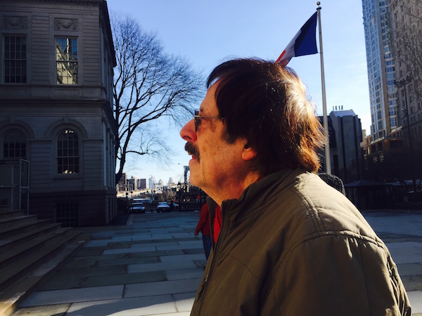 Ron Kolm, a co-founder of the NYC lit scene collective the Unbearables, listened to others as they took their turn on the steps of City Hall. Photo by Puma Perl.