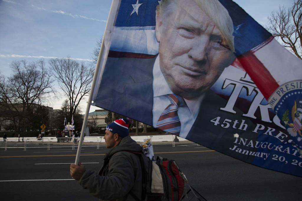 Nick, 41 year old vendor from Florida, walks along the National Mall with a Trump flag, day before the inauguration.