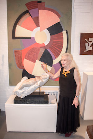 Lorrie Goulet at her Chelsea studio in 2016. In the background: “Equinox” (1993; acrylic, 84x60). Below is the sculpture “Goddess Of The Sea in Alabaster” (2014; 20x27x12). Photo by Dlo Slaughter/www.faithfocusflash.net.