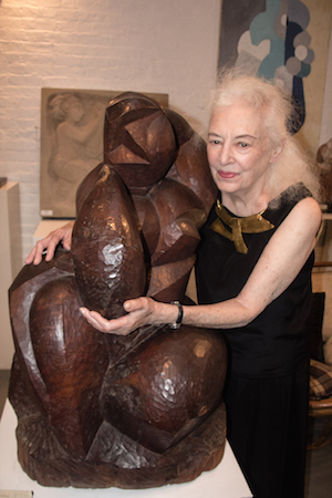 Lorrie Goulet stands in her W. 20th St. studio with 1952’s “Earth” (walnut, 36x32x30). Photo by Dlo Slaughter/www.faithfocusflash.net. 