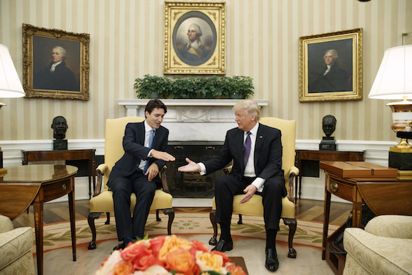 In an Oval Office meeting on Mon., Feb. 13, President Trump invites Canadian Prime Minister Justin Trudeau to touch his miniature imaginary friend and chief strategist, “Tiny Ivan.” AP Photo by Evan Vucci.