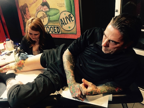 Michelle Myles of Daredevil Tattoo inked a dragon tail on Texan Michael Wyatt, at the Gus Wagner exhibition’s opening night reception. Photo by Puma Perl.