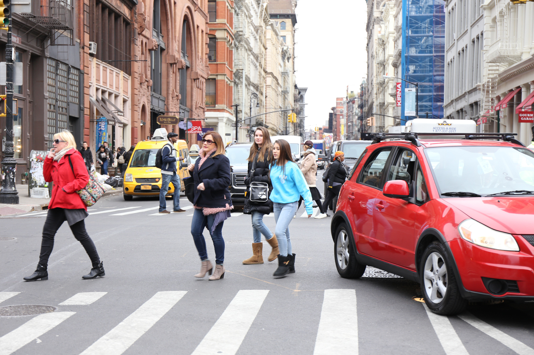 Pedestrians skirting a car blocking a crosswalk.