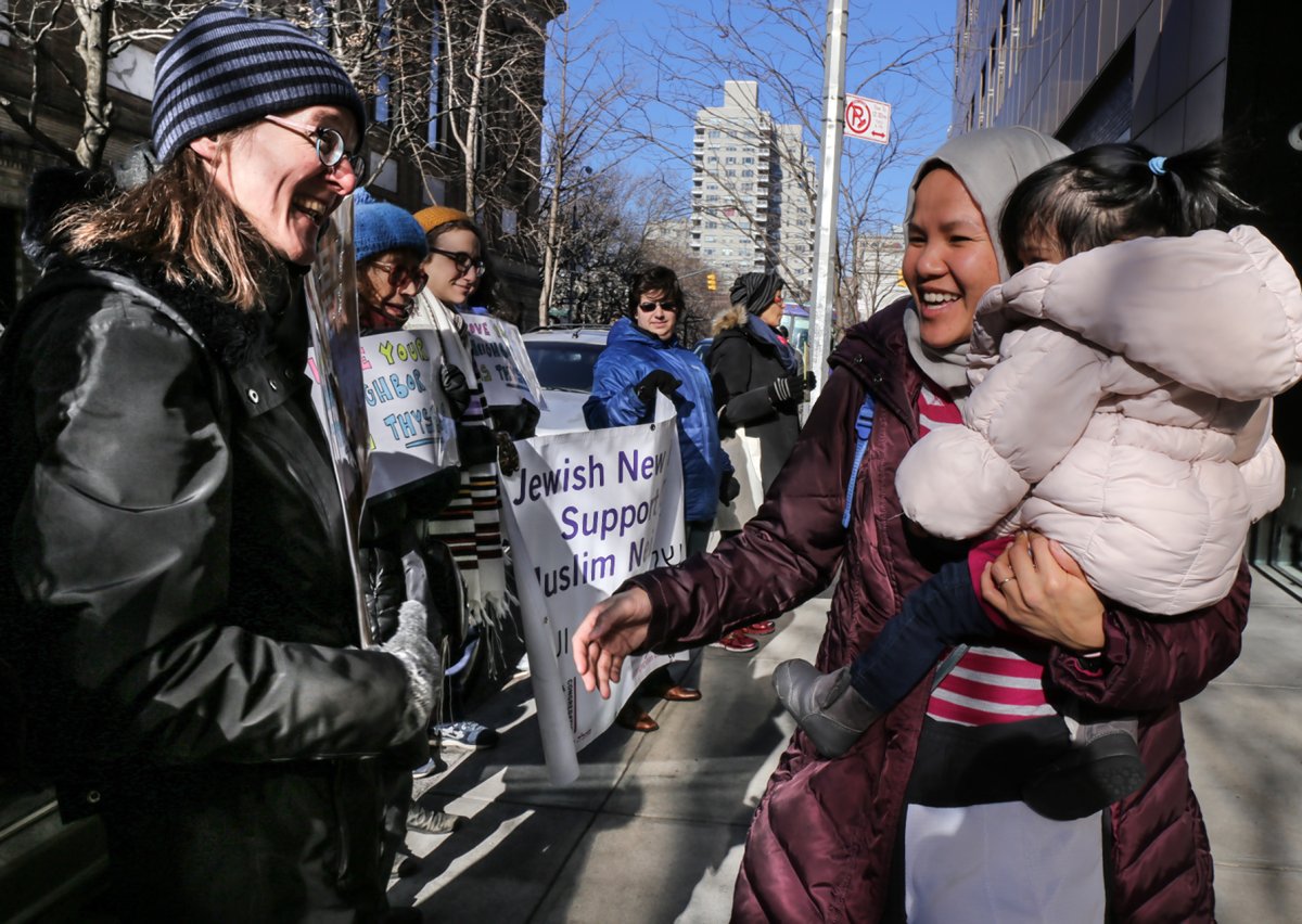 Members of Beit Simchat Torah at a Friday support vigil, left, greeted a woman outside the Islamic Center on Washington Square South. Photo by Tequila Minsky