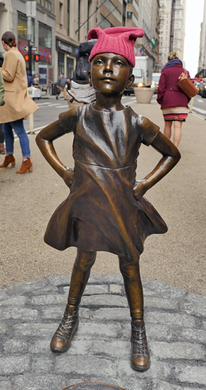 Photo by Milo Hess Onlookers couldn’t help crowning the sassy statue with a “pussy hat,” the two-pointed knitted cap that became a symbol of female defiance during the anti-Trump women’s marches that swept the nation the day after the Inauguration.