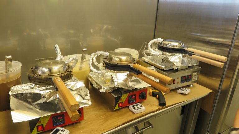 Each waffle is made to order, beginning with the pouring of the desired batter flavor onto these hot irons. It takes four minutes to cook.