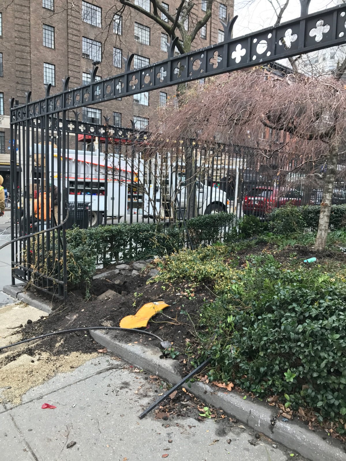 A runaway cab took out a big piece of the Jefferson Market Garden fence early Sunday morning. Part of its bumper was still visible inside the green spot later that morning when a garden volunteer snapped this photo. Photo courtesy Jefferson Market Garden