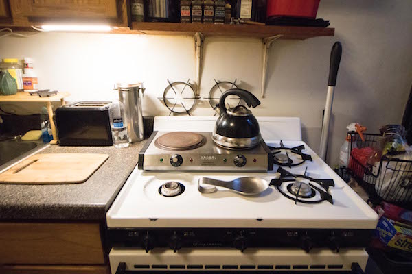 At least the stove makes a decent countertop: Kelly Maurer has been using a hot plate ever since the building’s gas was cut off in Feb. 2016. Photo by Caleb Caldwell.