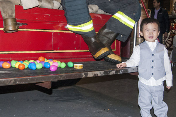Photo by Tony Falcone Two-year old Brayden Liu caught more eggs than he knew what to do with at the Fire Museum’s Easter egg hunt.