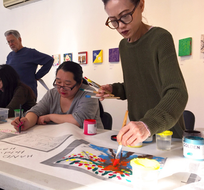 Community members painting as part of the mural project. | COURTESY: NEW YORK CITY MURAL ARTS PROJECT