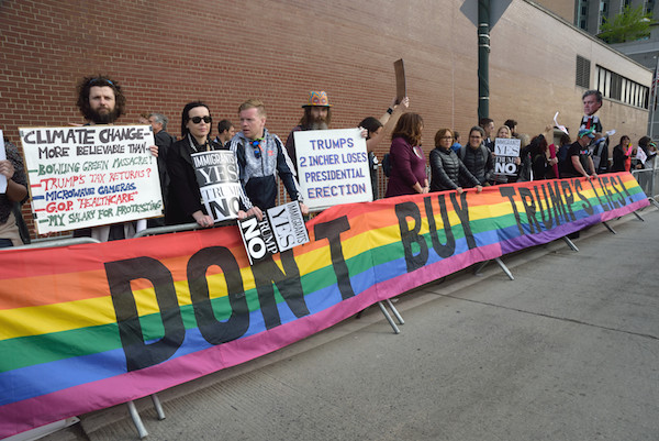 Rise and Resist and Gays Against Guns activists hoist a rainbow resistance banner created by the late Gilbert Baker, who died on March 31. | DONNA ACETO