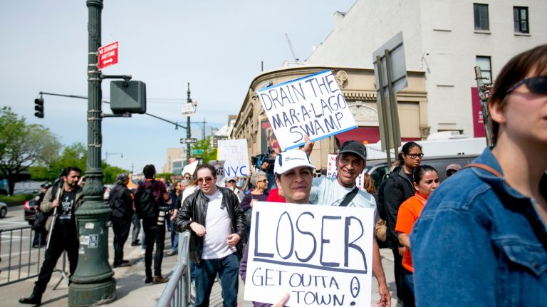 People hold their protest signs as they march down the West Side Highway in Manhattan before President Donald Trump's arrival at the Intrepid Sea, Air & Space Museum on Thursday, May 4, 2017. 