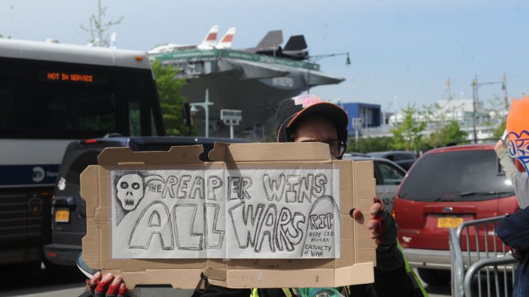 A protester stands outside the Intrepid Sea, Air & Space Museum, seen in the background. President Donald Trump was expected to arrive at the Intrepid, located in Manhattan, later on Thursday, May 4, 2017. 