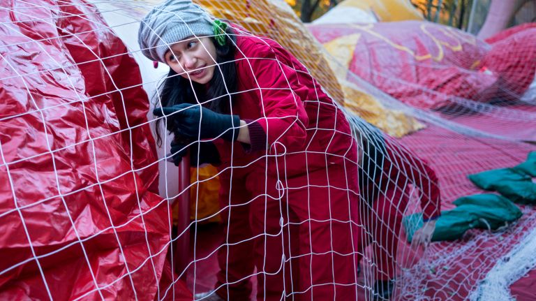 A member of the crew for the Ronald McDonald balloon works beneath the netting as inflation begins along 79th Street in Manhattan on Wednesday, Nov. 22, 2017, the day before the kickoff of the Macy's Thanksgiving Day Parade on Thursday.