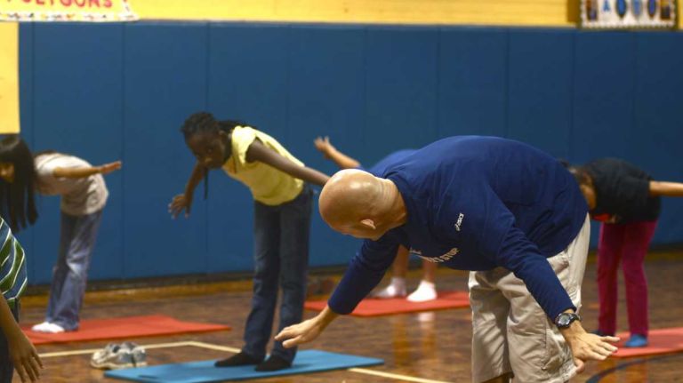A fifth grade class doing yoga in physical education class.