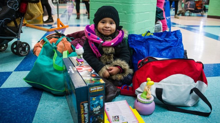 At a Jackson Heights Stop 'N' Swap, three-year-old Jennifer Lima keeps an eye on the goods her family snagged at the event.