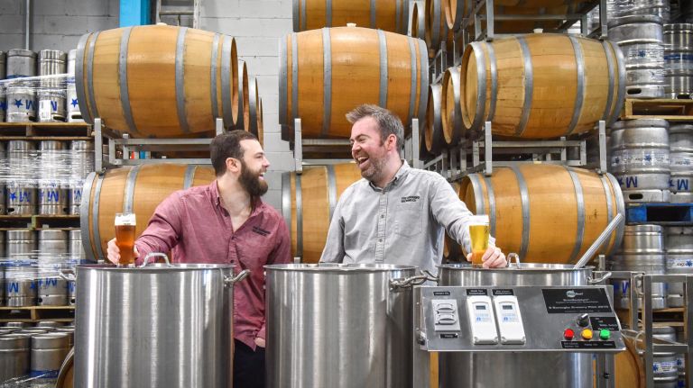 Co-founders Blake Tomnitz, left, and Kevin O'Donnell, standing in front of wine barrels where experimental brews are aging, on Feb. 15, 2018.