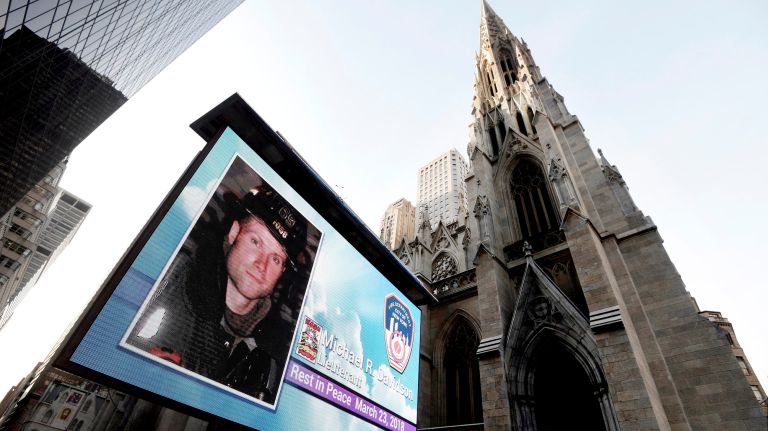 An electronic message board projects fallen firefighter Michael Davidson's picture outside the St. Patrick's Cathedral on Tuesday, ahead of his funeral.