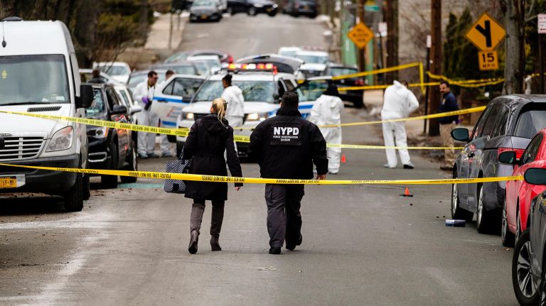 NYPD officers collect evidence at the scene on Highland Avenue on Staten Island where a woman with a gun was shot by police on Sunday.